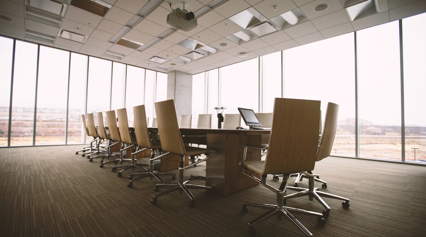 An empty boardroom table with documents.